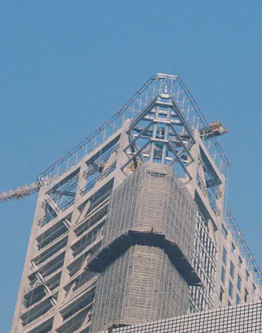 High-rise tower with a steel crown against a blue sky