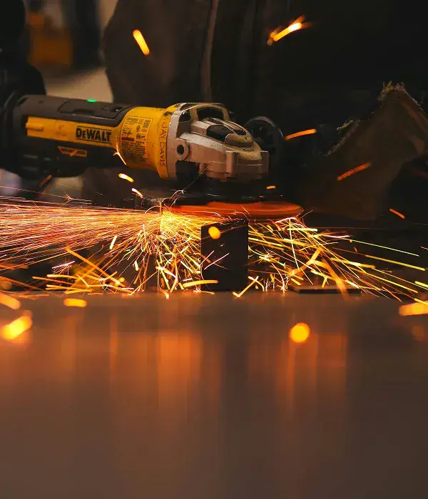 Grinder sparks flying across a workshop floor