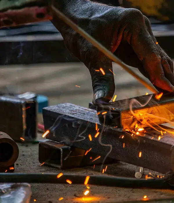 Gloved hand welding a steel section