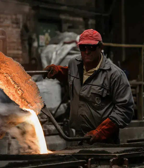 Foundry worker pouring molten metal